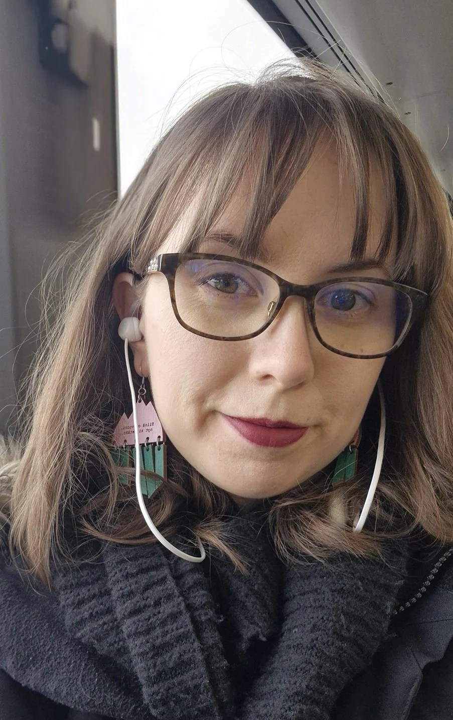 Kuvassa Varallisuusprojektin kirjoittaja Mari hymyilee kameralle kuulokkeet päässä